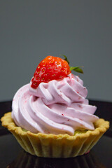 Artfully presented mini tartlets with a lavish pink cream twist and a glistening strawberry, exuding gourmet appeal.