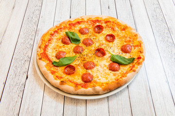 Delicious little spicy Italian salami pizza with oregano, basil leaves and mozzarella cheese