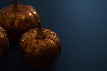 Calabazas doradas sobre un fondo negro, representando la tradición de Halloween.