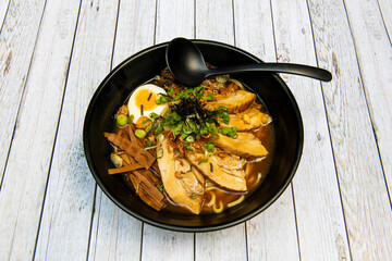Roasted pork char siu ramen with noodles, cooked bamboo, chives, boiled egg, chives and grated nori seaweed