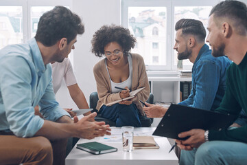 Confident business team having meeting while sitting in the office together