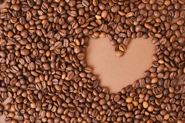 Heart made from coffee beans on brown background.