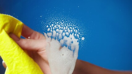 Hand spraying on window with detergent from dispenser, house cleaning and washing. Woman wiping with red cloth. Housekeeping, using spray with liquid soap. Antibacterial disinfectant, covid protection