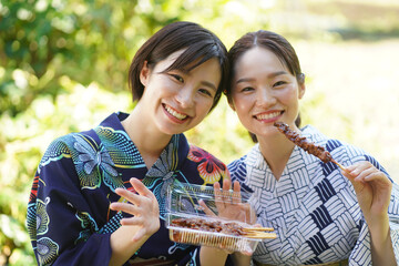 焼き鳥を持つ女性