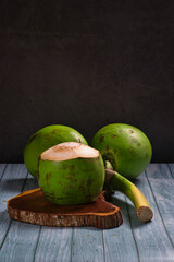 Coco verde aberto para consumo em mesa de madeira rústica 