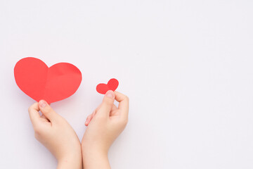 young girl holding red paper heart 