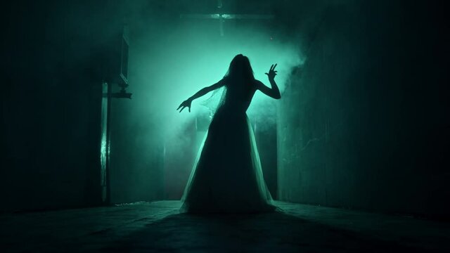 Dead walking zombie woman in dark corridor and mist close-up. Creepy bride wearing wedding dress with veil. Deceased fiancee returned to life. Horrible klip on halloween. Haunted house. 