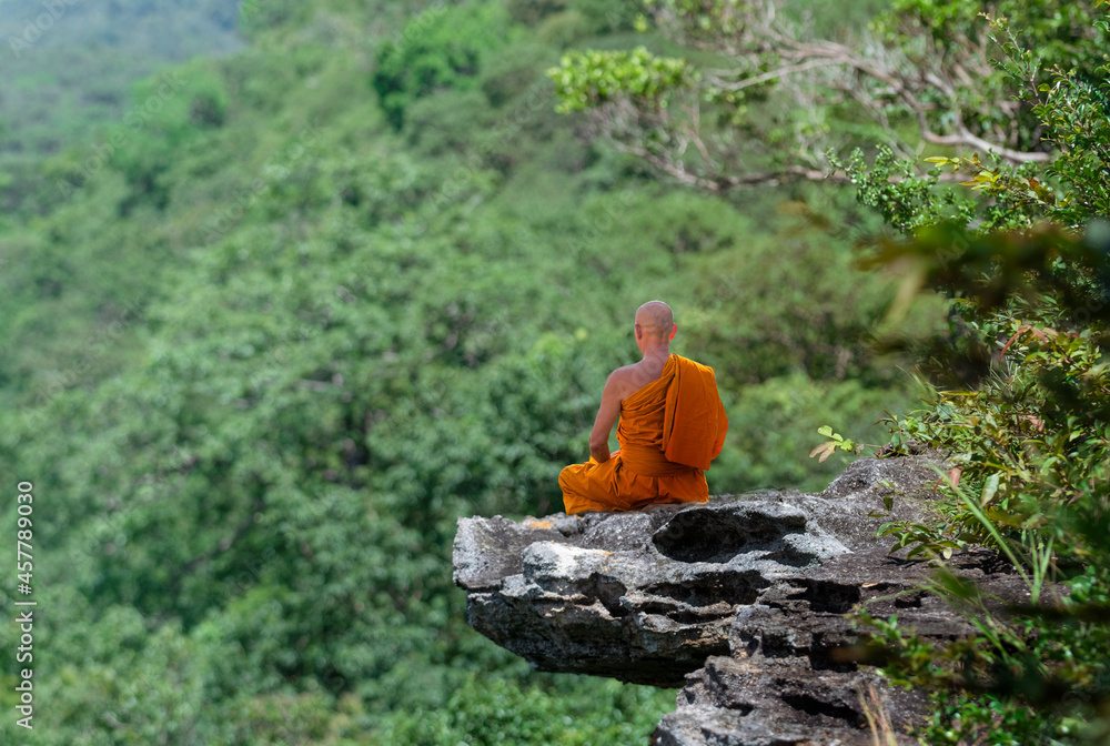 Wall mural Buddhist monk in meditation at beautiful nature background on high mountain