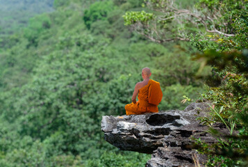 Obraz premium Buddhist monk in meditation at beautiful nature background on high mountain