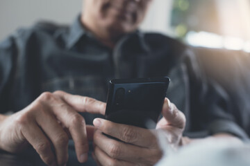 Man using mobile phone surfing social network at home