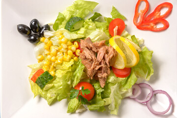 Tasty tuna salad with lettuce, fresh vegetables, tomatoes and corn. Healthy Green salad with tuna, corn and beans