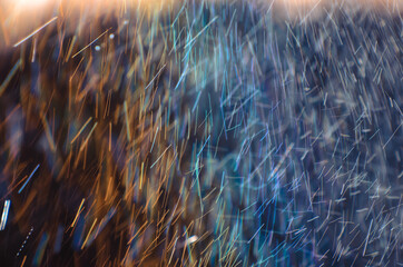Abstract raindrops nature background. Rain on long exposure. Rain drops motion. Trails of falling raindrops and rainbow colors