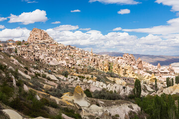 Fototapeta na wymiar トルコ　カッパドキアの鳩の谷から見えるウチヒサール城と下に広がる奇岩群と洞窟住居