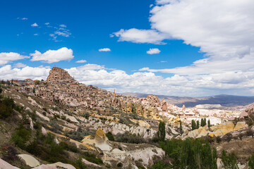 Fototapeta na wymiar トルコ　カッパドキアの鳩の谷から見えるウチヒサール城と下に広がる奇岩群と洞窟住居