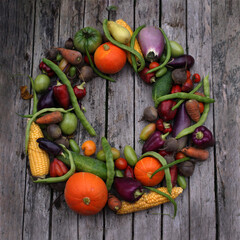 Autumn wreath of vegetables on a wooden background.