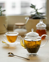 tea in a transparent glass teapot and cup