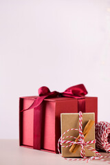 Red gift box with satin ribbon and package with cinnamon sticks and colorful rope for Christmas holiday 