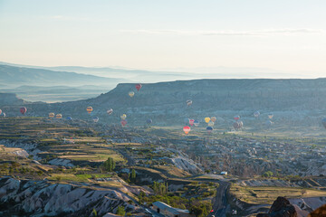 トルコ　カッパドキアのウチヒサール城から見える奇岩群とギョレメ国立公園の空を飛ぶ熱気球