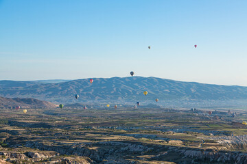 トルコ　カッパドキアのウチヒサール城から見える奇岩群とギョレメ国立公園の空を飛ぶ熱気球