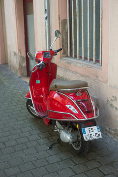 Colmar - France - 18 September 2021 - Rear view of red vespa scooter parked in the street