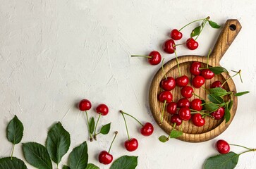 red cherries on white background, freshly picked cherries from the garden, scattered, messy, copy space text, wooden plate, fruits and vegetables, healthy, juicy berries, vitamins, harvested, fresh