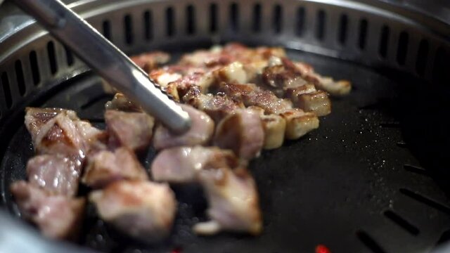 한국 정통 삼겹살을 숯불에 맛있게 굽는 모습 상추와 쌈장 마늘등에 싸서 먹는다