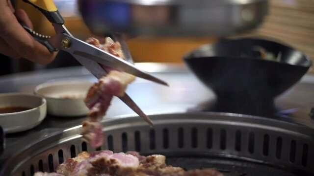 한국 정통 삼겹살을 숯불에 맛있게 굽는 모습 상추와 쌈장 마늘등에 싸서 먹는다