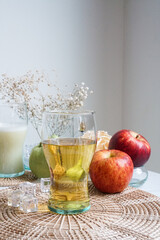 A glass of fresh organic apple juice decorates with red apple. Photo for healthy and detox drinks or beverages.