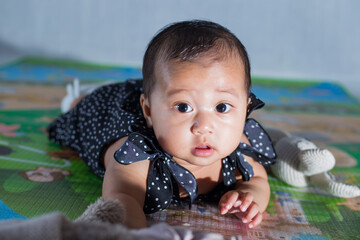 6 months old baby girl learning to crawl on the floor. Asian cute baby girl crawling on the floor...
