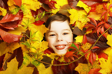 Artistic conceptual autumn boy portrait. Colorful leaves. Leaves of trees around an emotional face....