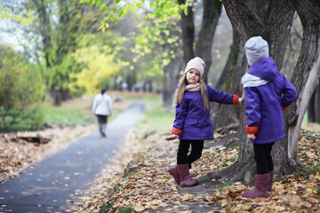 Fototapeta premium Leaf fall in the park. Children for a walk in the autumn park. Family. Fall. Happiness.