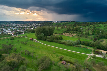Aerial view of a german city in dramatic weather. Rural against in foreground. Germany, Nürtingen.
