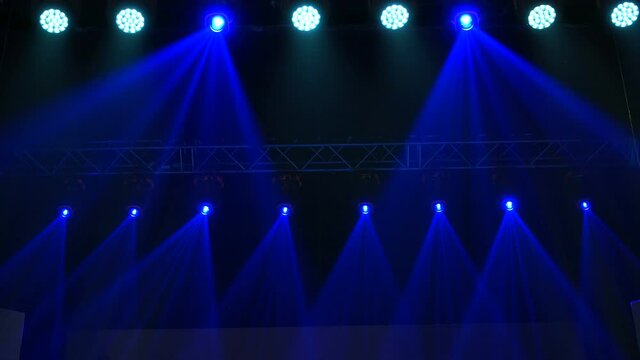 Animation of stage lights frame. Bright shiny stage lights flashing movement entertainment spotlight projectors in the dark, blue soft light spotlight strike on black background.