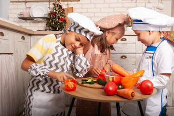 little boy thought about the benefits of vegetable salad for the day cooks children prepare salad at home in the kitchen