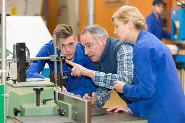 carpenter with apprentices in workshop