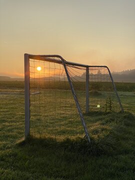 Fu&szlig;balltor bei Sonnenaufgang auf einer Wiese am Feldrand. Fussball, Tor, Sonne, morgens, goldenes Licht, Fussballspielen, Fr&uuml;hsport, Training, Wald, Landleben, Leben auf dem Land, sunrise, soccer