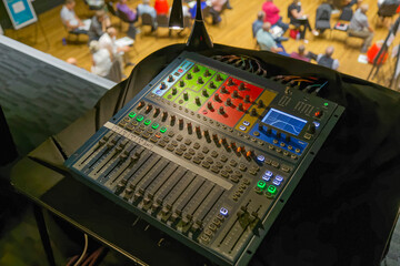 Closeup view of a professional sound mixer with people in the background
