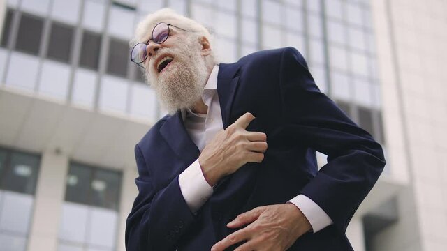 Elderly Gray-haired Man With Long Beard Writhing In Pain And Screaming Holding And Massaging Chest, Feeling Acute Pain In Heart, Suffering Stroke Or Heart Attack, Emergency Situation, Call 911