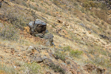 Rocky slope of a mountain with stones and grass