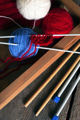 knitting - threads and knitting needles on a wooden table