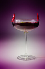Cocktail drink prepared with vodka, grenadine and lemon juice decorated with bird eye chillies in the shape of horns