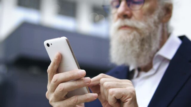 Advanced old man scrolling, swiping and zooming media content on modern gadget