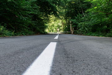 Road, asphalt that passes through the forest. Photo from the base of the road.