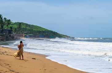 A girl walking on the beach, Anjuna Beach, Goa, India