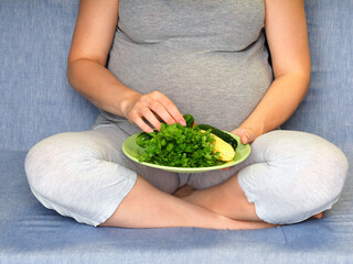 pregnant woman eating fresh green vegetables