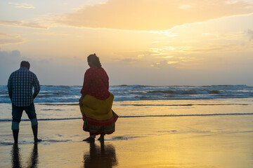 silhouette of a couple walking on the beach, Baga Beach, Goa, India - obrazy, fototapety, plakaty