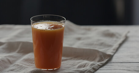 pumpkin juice in tumbler glass on linen cloth