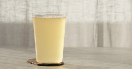 closeup ginger beer in a tumbler glass on oak table with copy space