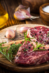 Fresh Raw Meat on Wooden Plate. Beef Steak Cut with Spices and Herbs