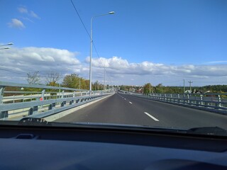 road with horizon on blue sky and clouds at daytime view from car.